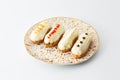 Four eclair cakes on a white plate isolated on white background Royalty Free Stock Photo