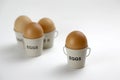 Four eggs in egg cups on a whote table white background Royalty Free Stock Photo