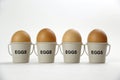 Four eggs in egg cups on a whote table white background Royalty Free Stock Photo