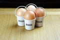 Four eggs in egg cups on a wooden table black background Royalty Free Stock Photo