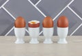 Four eggs in eggcups on wood kitchen surface