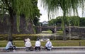 Four elderly women sitting and drawing a landscape with Imperial Palace in Tokyo