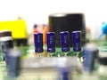 Four electrolytic capacitors mounted on printed circuit board in a row Royalty Free Stock Photo