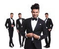 Four elegant man with leader buttoning his tux in front