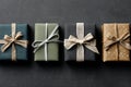 Four elegantly wrapped gifts in various colors and textures arranged in a row on a dark surface Royalty Free Stock Photo