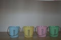 Four Empty Bucket Shaped Pastel Coloured Egg Cups on a Wooden Sheld Royalty Free Stock Photo