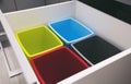 Four empty plastic trash bins in the shelf in the kitchen