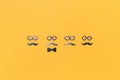 Four faces with mustaches for Movember on yellow orange Royalty Free Stock Photo