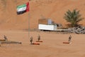 Four falcons stand at their training post with a UAE Flag in the background Royalty Free Stock Photo