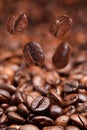 Four falling beans and dark roasted coffee Royalty Free Stock Photo