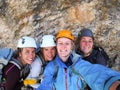 Four female climbers celebrate on the mountain summit by taking a group photo