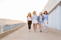 Four female friends walking down at walkway, sunshine background Royalty Free Stock Photo