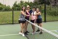 Four Female Pickleball Players Touch Paddles