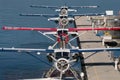 Four float planes are seen in symmetrical formation at their dock in the harbor