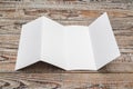 Four - fold white template paper on wood texture . Royalty Free Stock Photo