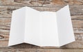 Four - fold white template paper on wood texture . Royalty Free Stock Photo