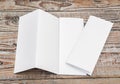 Four - fold white template paper on wood texture . Royalty Free Stock Photo