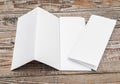 Four - fold white template paper on wood texture . Royalty Free Stock Photo