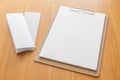 Four fold white template paper with wooden clipboard on wood background Royalty Free Stock Photo