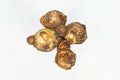 Fresh harvested organic taro corms,satoimo potatoes or taro roots on white background