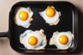 Four fried eggs in a cast iron frying pan. Preparing breakfast