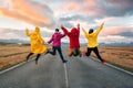 Four friend jump on the road at sunset