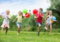 Four friendly kids running on green lawn