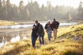 Four friends having fun walking beside a lake Royalty Free Stock Photo