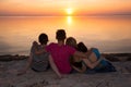 Four friends hugging on the beach and admiring the sunset Royalty Free Stock Photo