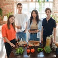 Four friends looking at camera together in kitchen at home Royalty Free Stock Photo