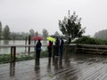Four friends observing the Fraser river in Fort Langley on a rainy day.