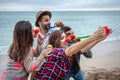 Four friends with red noses take a selfie and celebrate a birthday on the beach