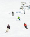 Four friends skiers boarders front view ski downhill on holiday in ski resort have fun together in mountains