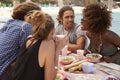 Four friends talking at a table by the sea, side view, Ibiza Royalty Free Stock Photo