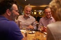 Four friends talking together during a meal at a restaurant Royalty Free Stock Photo