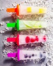 Four frozen fresh fruit popsicles on sticks