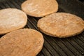 Four frozen hamburgers on the grill. Frozen fast food