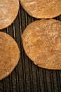 Four frozen hamburgers on the grill. Frozen fast food