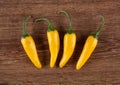 Four fruits of yellow fresh chilli pepper on a wooden background