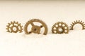 Four gears set in sand in a row side view. brass gears and sand Royalty Free Stock Photo