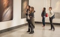 Four girl friends looking at modern painting in art gallery Royalty Free Stock Photo