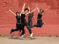 Four girls jumping on background of wall Royalty Free Stock Photo