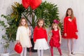 Four girls in red and white clothes with balloons