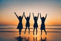 Four girls silhouette jumping on the beach with the sunset in the background. Royalty Free Stock Photo