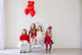 Four girls in a white room with red holiday balloons