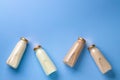 Four glass bottles of flavoured milk on blue background top view