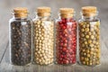 Four glass jars with black white red and green pepper Royalty Free Stock Photo