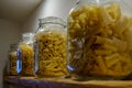 Four glass jars with pasta standing on the shelf Royalty Free Stock Photo
