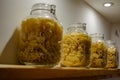 Four glass jars with pasta standing on the shelf Royalty Free Stock Photo