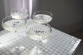 Four glasses with champagne on a light table surface reflecting soft sunshine rayson Royalty Free Stock Photo